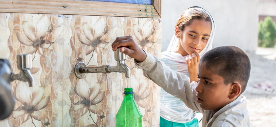 Young boy fills up water bottle from tap