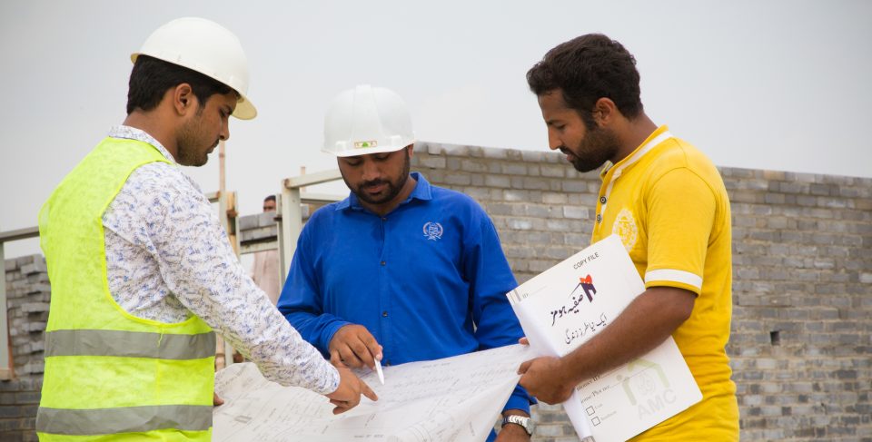 Men at building site looking at plans