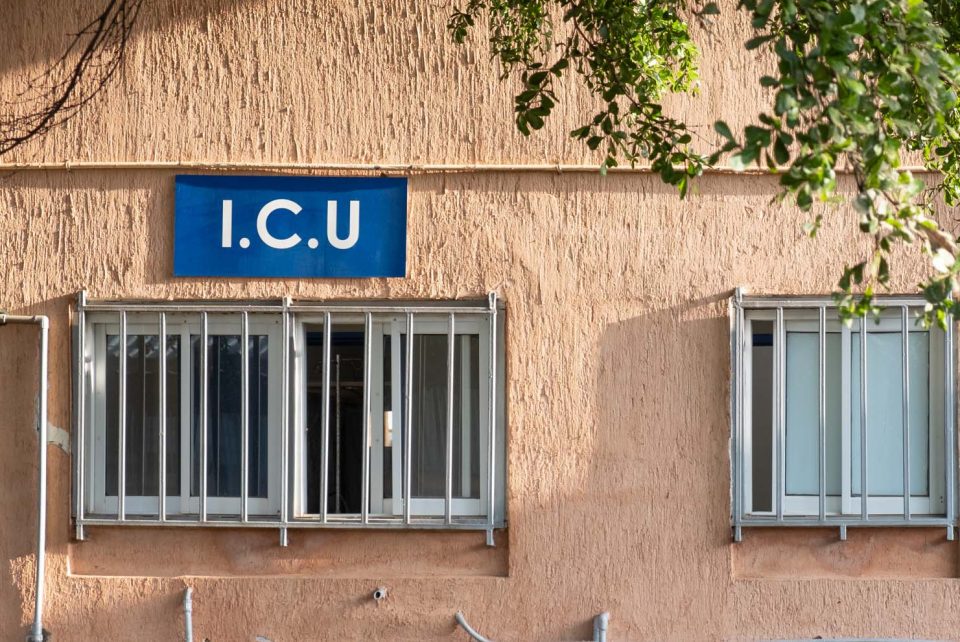 Blue ICU sign outside building above a window