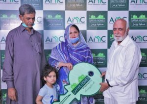 Family receiving key to affordable housing in Pakistan